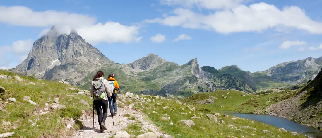 Zwei Wanderer mit Trekkingstöcken auf einem Bergweg