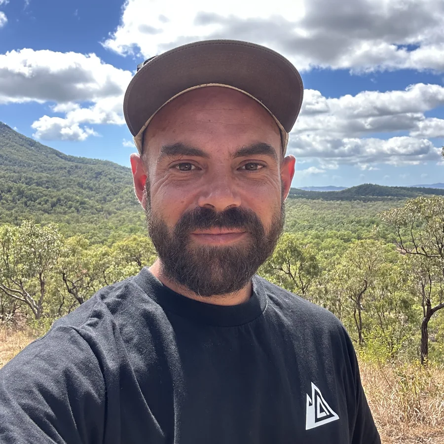 Kai Freund, Gründer von BERGBOUND, im BERGBOUND-Shirt vor einer Buschlandschaft in Australien